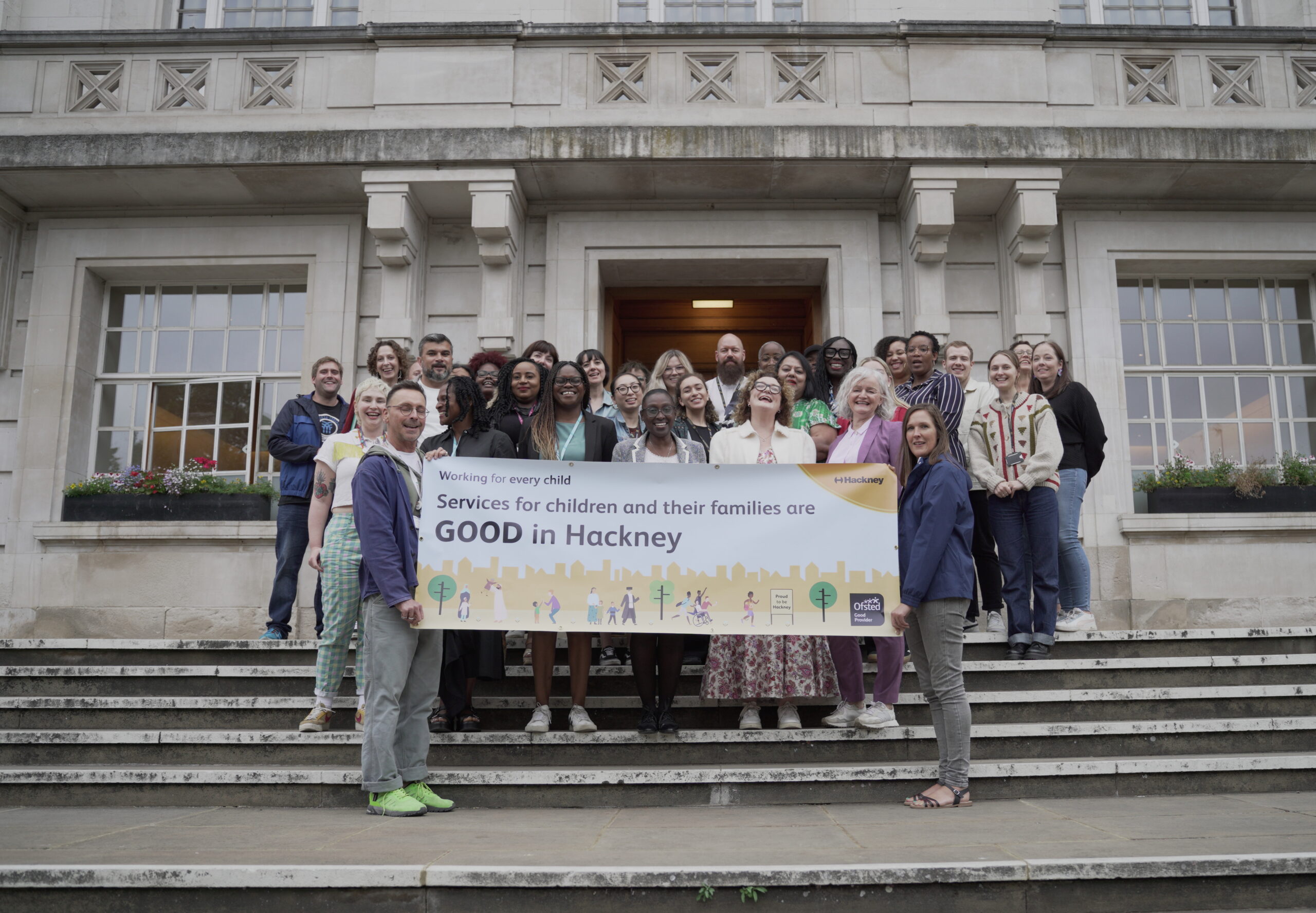 Staff from Hackney Children and Family Services holding their Ofsted rating banner